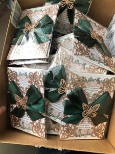 a box filled with lots of green and gold bow tie bows on top of each other