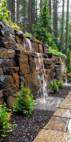 a stone wall with water coming out of it in the middle of a garden area