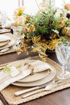 a table set with place settings and flowers