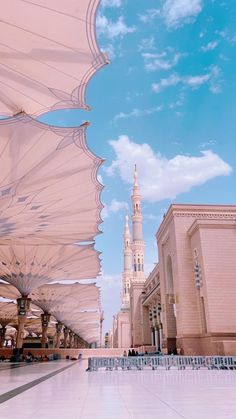 the inside of a large building with many white umbrellas on it's sides