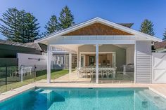 a house with a swimming pool in the yard and covered patio area next to it