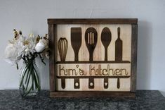 a wooden sign that says hum's kitchen with utensils and spoons