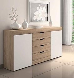 a white vase sitting on top of a wooden dresser