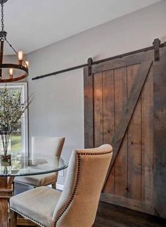 a dining room table and chairs in front of a barn door with sliding glass doors