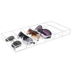 three pairs of sunglasses sitting on top of a white shelf