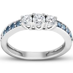 a three stone ring with blue and white stones on the sides, set in 18k white gold