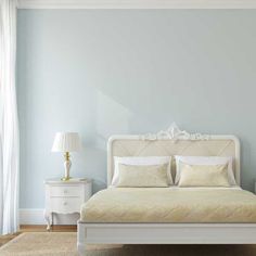 a white bed sitting in a bedroom next to a window