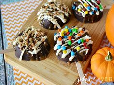 chocolate covered donuts decorated with sprinkles and candy on a cutting board