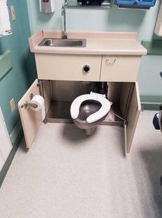 a small bathroom with a sink, toilet and cabinet in it's stall area