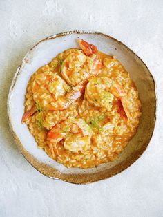 a bowl filled with rice and shrimp on top of a table