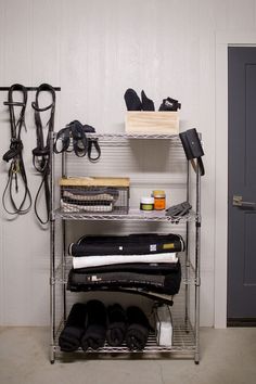 a metal shelf filled with lots of different types of clothing and shoes next to a door