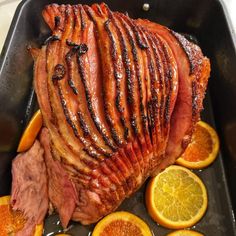 a roasting pan filled with sliced oranges and meat