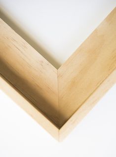 the corner of a wooden frame with white walls