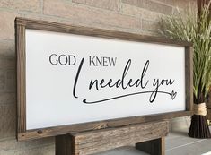 a sign that says god knew i needed you on the side of a wall next to a potted plant