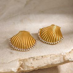 Made with sparkling rhinestones, these earrings are the perfect accessory for any occasion. With their unique scallop shell design, you'll stand out in style. - Color: Gold- Material: Stainless Steel, Rhinestones- Style: Earrings- Closure Type: Stud- Gender: Women Scallop Shell, Shell Design, Shell Beach, Daily Jewelry, Scallop Shells, Metal Texture, Trendy Necklaces, Gold Piece, Earring Type