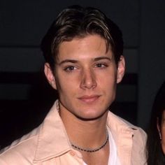 two people standing next to each other wearing necklaces