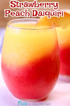 two glasses filled with orange and red drink on top of a white tablecloth next to each other