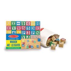 the wooden alphabet blocks are in front of a roll of paper and two pieces of wood