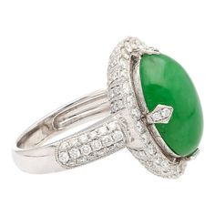 This is part of Chairish’s Fine Jewelry assortment.  Introducing a captivating 18K White Gold Ring, weighing 7.04 grams and adorned with a prong setting for timeless elegance. At the heart of this ring is a vibrant 7.29 carat cabochon-cut "A" grade Jadeite Jade, showcasing a rich green hue. Accentuating the Jade are 126 round-cut Diamonds, totaling 1.19 carats, delicately arranged to enhance the ring's overall brilliance.  Fixed with an intricate milgrain finish around the gemstones.   Item Deta Gia Certified Elegant Oval Cabochon Jewelry, Luxury Green Diamond Ring For Formal Occasions, Timeless Green Diamond Round Ring, Fine Jewelry Tsavorite Diamond Ring For Formal Occasions, Elegant Cabochon Emerald Ring For Formal Occasions, Gia Certified Tsavorite Diamond Ring For Formal Occasions, Exquisite Green Rings For Formal Occasions, Timeless Green Rings For Formal Occasions, Green Ring With Polished Finish For Formal Occasions