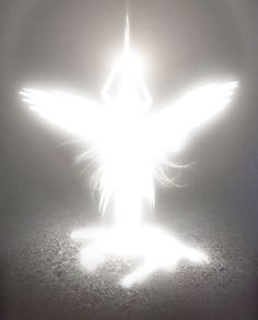 a person standing in the middle of a street with an angel on it's back