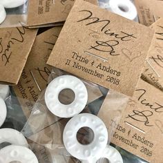 wedding favors are laid out on top of each other in plastic wrappers and paper tags