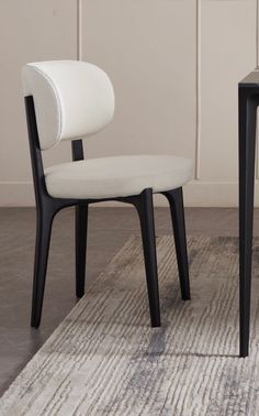 two chairs sitting next to each other on top of a carpeted floor in front of a white wall