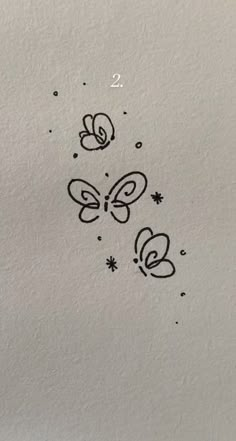 some black and white drawings on the side of a piece of paper with butterflies flying around it