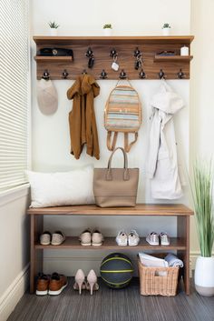 a coat rack with shoes, purses and other items hanging on the wall next to it