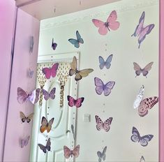 a room filled with lots of butterflies on the wall next to a white refrigerator freezer