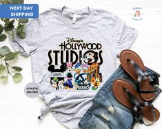 "Disney's Hollywood Studios Shirt, Family Shirt, Mickey and Friends Tee, Family Vacation Shirt, Funny Travel Tee ORDERING: 1. Review all photos 2. Choose Size and Color from drop-down menu 3. If personalization box is available, add your text color 4. Add each shirt to cart one at a time 5. Click \"Add to Cart\" - you can go back to add more products 6. Click \"Proceed to Checkout\" 7. Add note to seller for any requests * We use several different brand shirts, all of them are premium quality and soft shirts. The brands we send may vary depending on our stock situation. * We guarantee 100% satisfaction. The brands we use in- clude premium quality shirt brands such as Bella Canvas, Gildan Soft Style, Circle, Outlash. BULK DISCOUNTS AND SPECIAL REQUESTS: We offer bulk discounts and are open Casual Tops With Character Print For Theme Park, Casual Crew Neck Tops For Theme Park, Themed Graphic Print Shirt For Disney Trips, Pop Culture Graphic Print Shirt For Disney Fan Events, Casual Graphic Print Tops For Theme Park, Disney Family Shirts Hollywood Studios, Disney Style Graphic Print Shirt For Disney Trips, Shirts For Hollywood Studios, Disney Graphic Print Shirt For Disney Trips