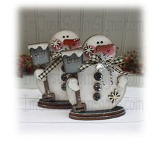 two snowmen sitting on top of each other in front of a christmas ornament