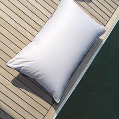 a white pillow sitting on top of a wooden dock