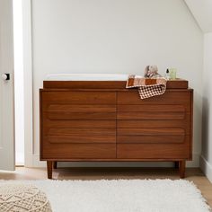 a baby's crib in the corner of a room with a rug on the floor