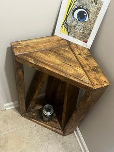 a wooden shelf with a jar on top of it next to a wall mounted poster