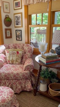 a living room filled with furniture and pictures on the wall next to a window covered in curtains