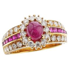 A Van Cleef & Arpels Ruby Cabochon and Diamond Halo Ring made in 18k Yellow Gold. Circa 1980s. The ruby cabochon is appx. 1.20 carats and there are 12 round brilliant-cut diamonds surrounding the ruby with square cut rubies and diamonds on each side. Stamped VCA 750, and serial number. The weight is 6.44 grams and the ring size is 6.75 US.  1591-FHJARTOM Luxury Cabochon Ruby Ring For Wedding, Luxury Cabochon Diamond Ring For Anniversary, Vintage Cluster Ring, Gold Vans, Van Cleef & Arpels, Ruby Diamond Rings, Ruby Stone, Diamond Cocktail Rings, Van Cleef Arpels