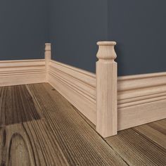 the corner of a room with wood flooring and gray walls, along with a wooden post