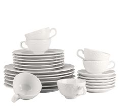 a stack of white cups and saucers sitting on top of each other