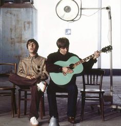 two young men sitting on chairs playing guitars