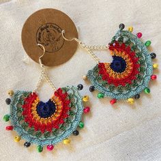 a pair of colorful crocheted earrings with beads