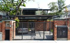 a car is parked in front of a brick building with an iron gate and glass doors