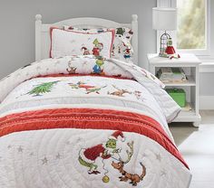 a white bed with red and green bedspread in a child's room