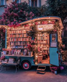 an old truck is decorated with flowers and bookshelves for the book store's display