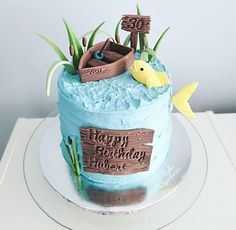 a blue birthday cake decorated with an image of a boat and fish