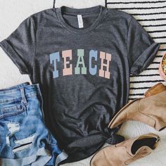 Teacher T Shirt, Pastel Teach Shirt, Teacher Shirt, Teacher Gifts, Elementary School Teacher Tee, Teach Tee Looking for more teacher/back to school apparel? Check these out: https://www.etsy.com/shop/TheGraphicPeach?ref=seller-platform-mcnav§ion_id=34195008 Our shop uses direct-to-garment printing to make our products. The design ink is sprayed on, then allowed to soak into the fibers of the garment. This process yields fine quality prints and a smooth finish on the garment. BELLA + CANVAS UNISE Cotton T-shirt With Name Print For Teaching, School Spirit Letter Print Top, Graphic Tee With Text Print For Teaching, Relaxed Fit Tops With Text Print For Teaching, School Apparel, Teach Shirt, Travel Hoodie, Libra Gifts, Teacher Back To School