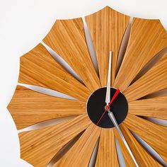 a clock made out of bamboo sticks with red hands