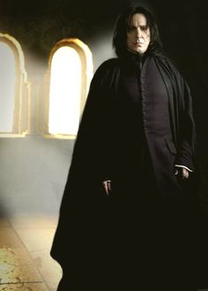 a man standing in front of a window wearing a black robe and holding his hands on his hips