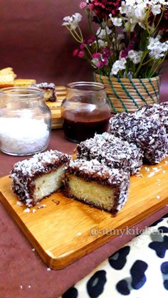 a wooden cutting board topped with pieces of cake