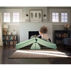 a child is playing with a green wooden structure