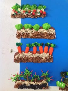 carrots and other vegetables made out of chocolate on a blue board with white walls